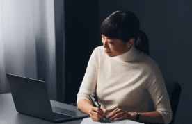 Woman doing obituary research on a laptop